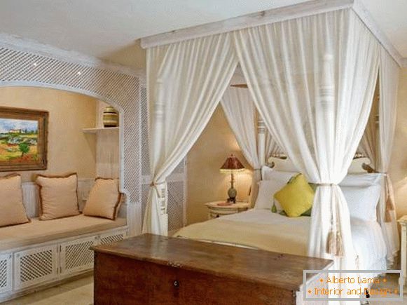 Design della camera da letto con mobili bianchi e baldacchino