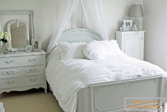 Camera da letto romantica con letto bianco e arredamento