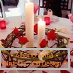 Decorazione di un tavolo con candele e petali di rosa