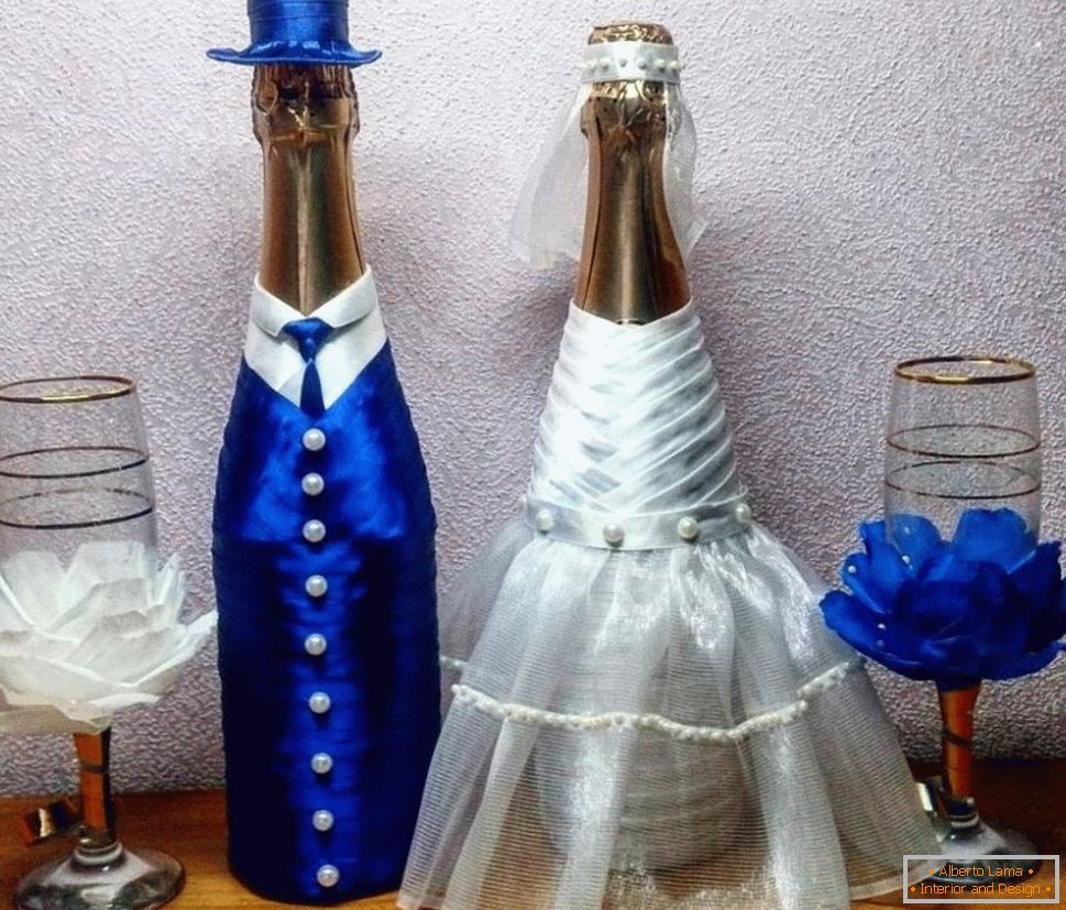 Bottiglie nuziali in abiti della sposa e dello sposo