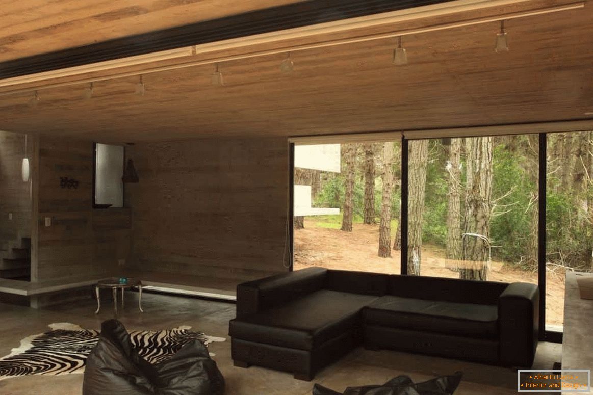 Soggiorno con finitura in legno in una casa in legno con una finestra panoramica