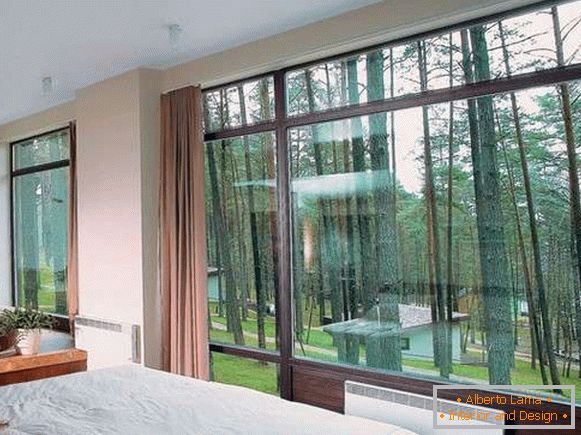 Camera da letto con ampie finestre all'interno di una casa privata