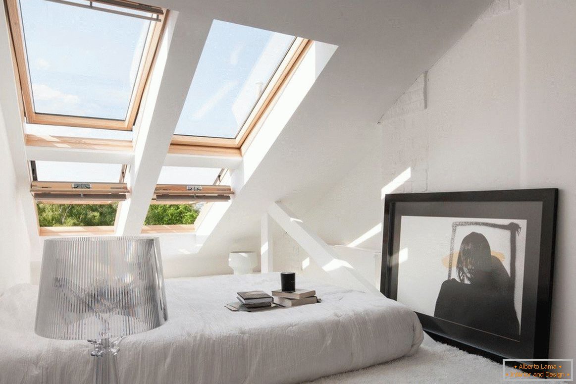 Camera da letto accogliente con finestre sulla pendenza del tetto