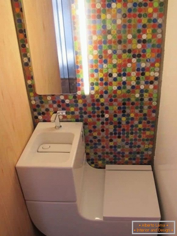 Un piccolo bagno con una moderna toilette combinata e un mosaico luminoso