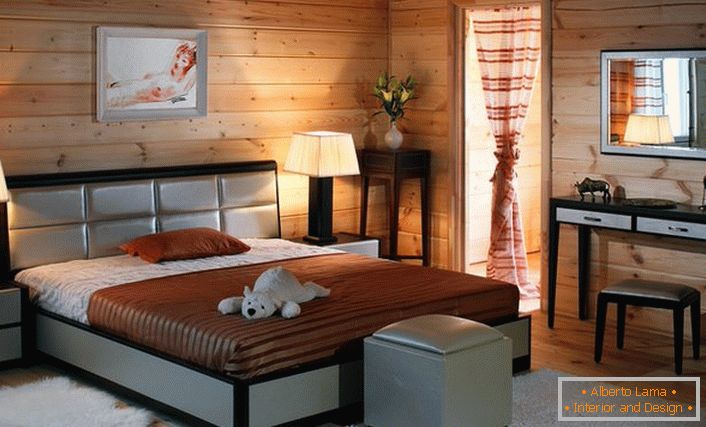 Le pareti della stanza dalla struttura in legno sono armoniosamente combinate con i mobili della camera da letto del colore del cenogee.