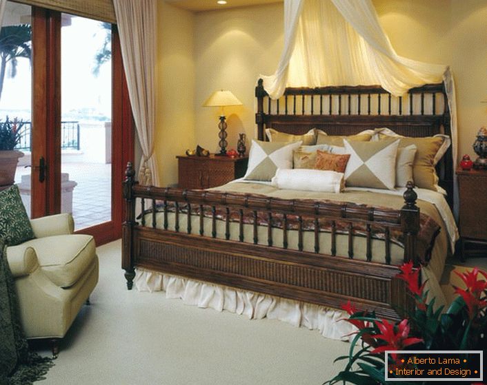 Letto di lusso in camera da letto nello stile dell'eclettismo. Baldacchino sopra il letto, le tende di luce sulle porte che conducono alla veranda rendono la camera accogliente e romantica. 