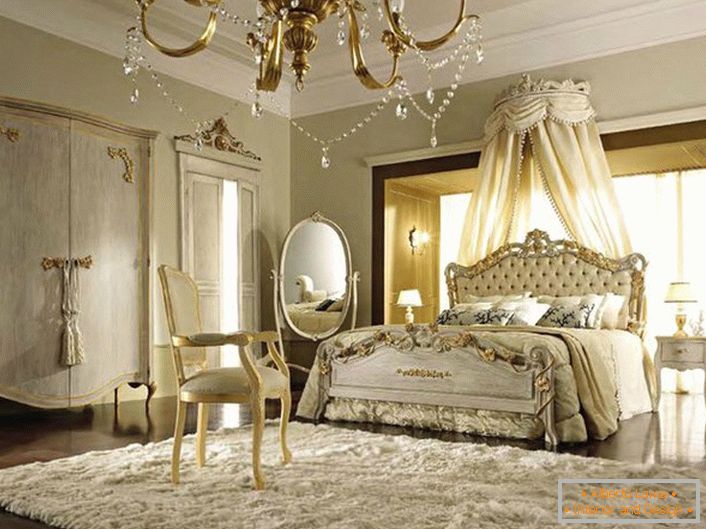 Baldakhin sopra il letto fu rimosso dietro la testiera. Le tonalità beige morbide si fondono con successo con gli elementi in oro del decoro.