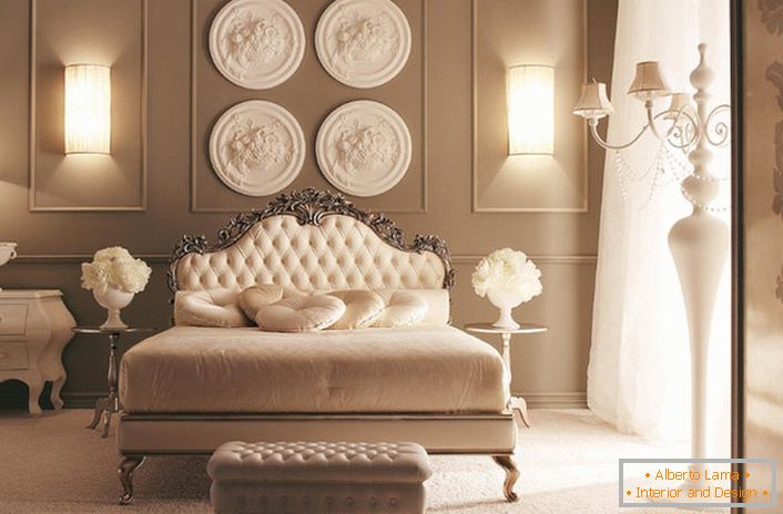 A capo del letto, il muro è decorato con una composizione di stucchi di design. Decorazione da camera da letto squisita in stile Art Deco.