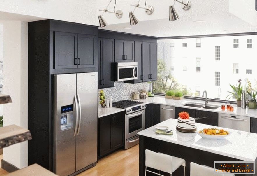 La combinazione di un frigorifero in acciaio e mobili scuri in cucina