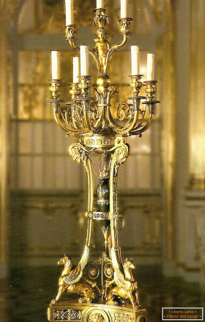 Un candelabro d'oro nobile e raffinato per nove candele decorerà l'interno di qualsiasi casa di campagna o di caccia.