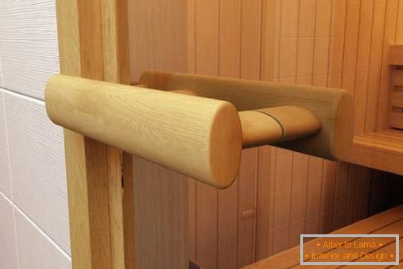 Manico in legno per porte in vetro in una sauna fatta di calce