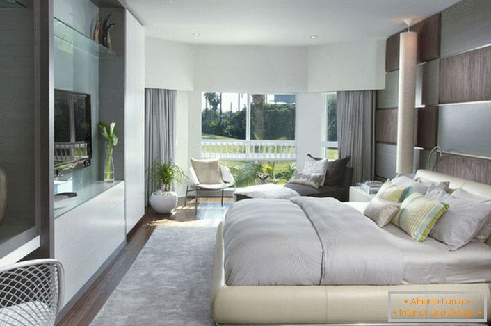 Morbido letto sfuso in camera da letto in stile moderno. I mobili con una superficie lucida si adattano bene alla composizione generale degli interni.