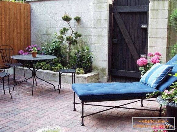 Patio con divano e mobili in ferro battuto