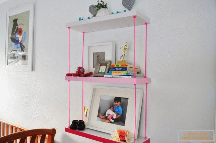 Una libreria per una camera dei bambini con corde rosa