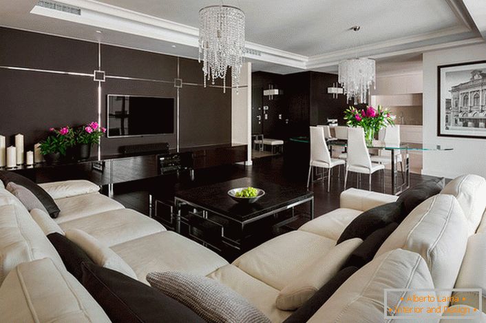 Nell'interno del soggiorno, due colori competono: bianco e marrone. Il designer risolve il problema dipingendo, lampadari e fiori.