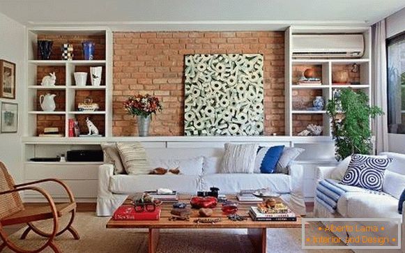 Interno del soggiorno con un muro di mattoni e mobili bianchi