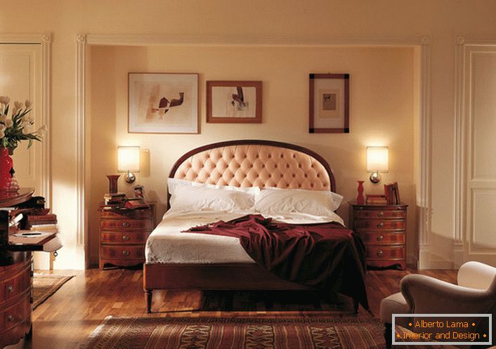 Il nobile stile inglese nella camera da letto è attraente e modesto. Il centro dell'attenzione è un letto in una testiera alta, che è costellato da un panno beige chiaro morbido.