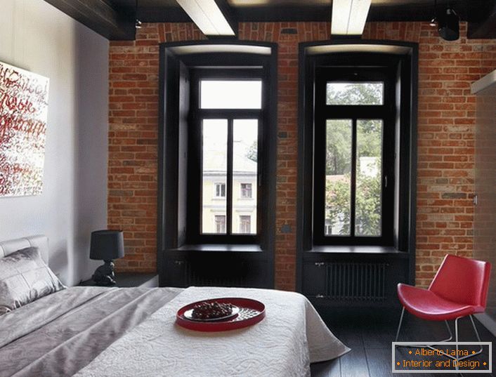 Una combinazione vincente di colori classici: bianco, rosso, nero all'interno dello stile loft della camera da letto.