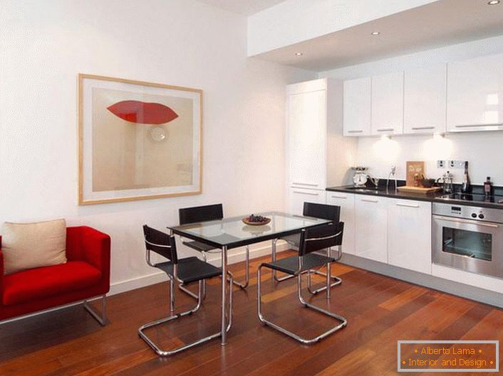 Cucina elegante con accenti di rosso. Lo stile minimalista è un'opzione vincente per la progettazione di appartamenti studio. 