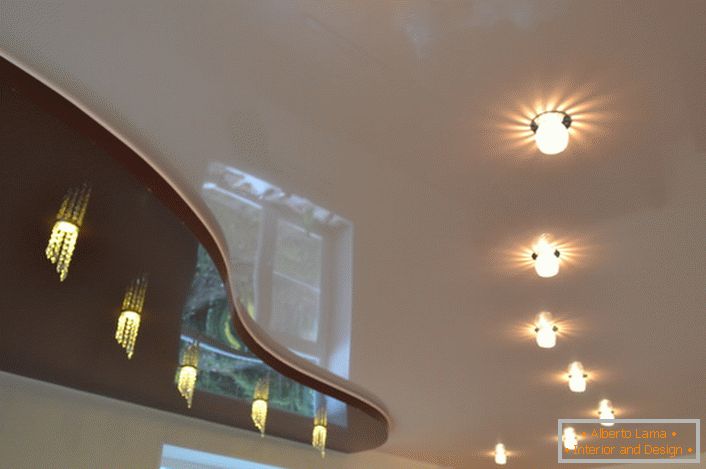 Percorsi illuminati originali pensati per un soffitto a due livelli. Sotto l'inserto di ciliegio scuro, suggerisce l'installazione di un bancone da bar.
