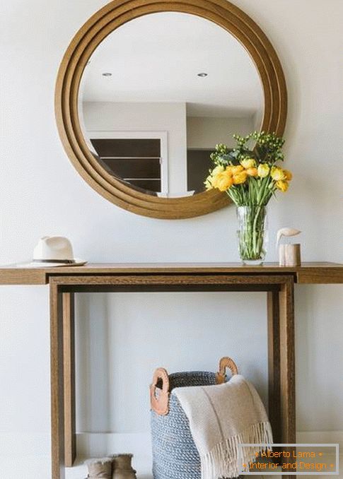 Specchio rotondo nel corridoio con finiture in legno