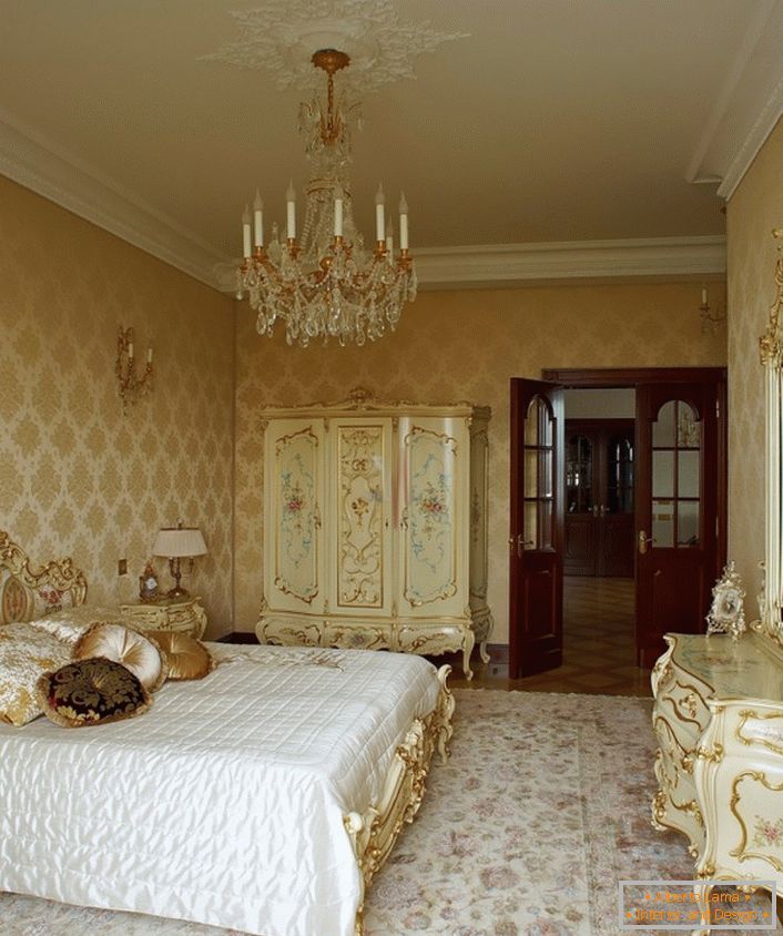 Il raffinato lampadario e il soffitto con stucchi si fondono armoniosamente con i mobili in legno dai colori dorati. 