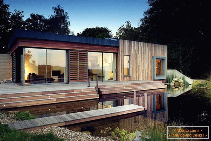 Casa modulare di piccole dimensioni per cottage sulla riva di un bacino artificiale. Una soluzione insolita nello stile dell'alta tecnologia.