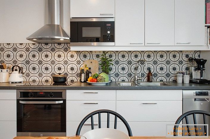Set da cucina bianco con un minimo di accessori scelti appositamente per una piccola cucina. L'arredamento non è solo attraente, ma è pratico e funzionale.
