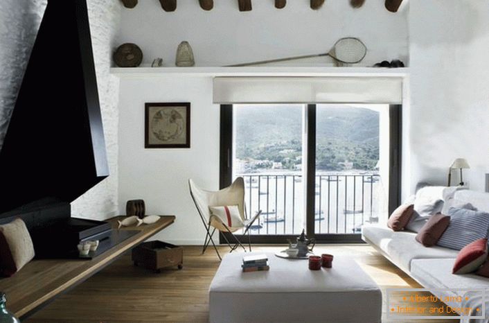 Lo stile mediterraneo implica un interno ben illuminato. Pertanto, le finestre del soggiorno non sono appese con tende o tende spesse.