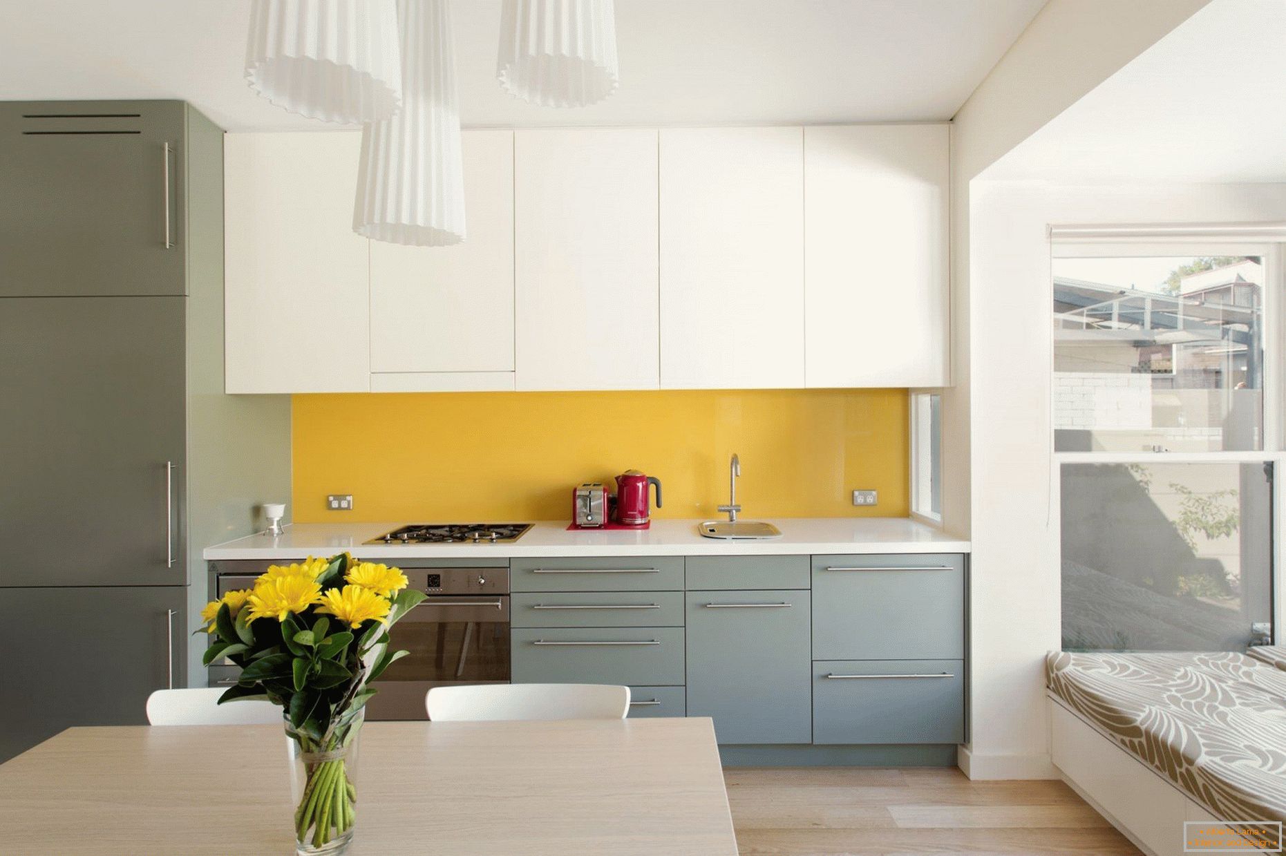 Grembiule giallo in cucina bianca e grigia