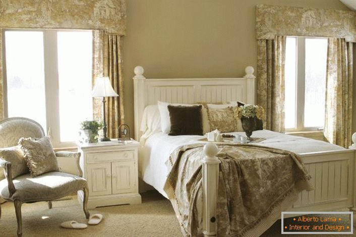 Una camera da letto per gli ospiti in stile country in una casa di campagna in una delle province della Francia. L'esempio corretto della selezione di mobili per il posizionamento in questo stile.