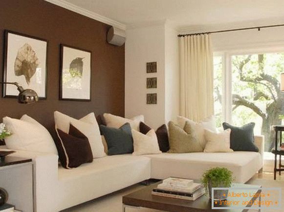 Pareti marrone scuro nel design del soggiorno con un divano bianco