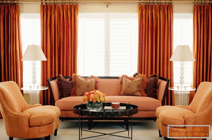 Un esempio di combinazione ideale di tende romane traslucide e tende pesanti con tappezzeria sotto il colore degli interni del soggiorno e dei mobili.