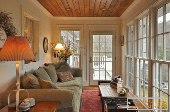 Veranda vetrata con un grande divano e lampade