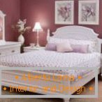 Interno camera da letto lilla con mobili bianchi