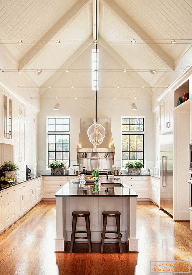 Una cucina enorme in colori beige con pavimenti in legno