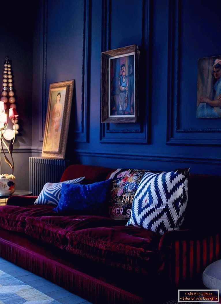 Il divano bordeaux su uno sfondo di pareti blu scuro