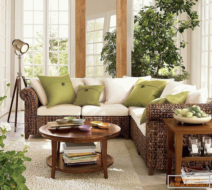 Grandi finestre con cornici in legno lasciano entrare in soggiorno in eco-stile una quantità sufficiente di luce solare, che dovrebbe prevalere nella stanza.