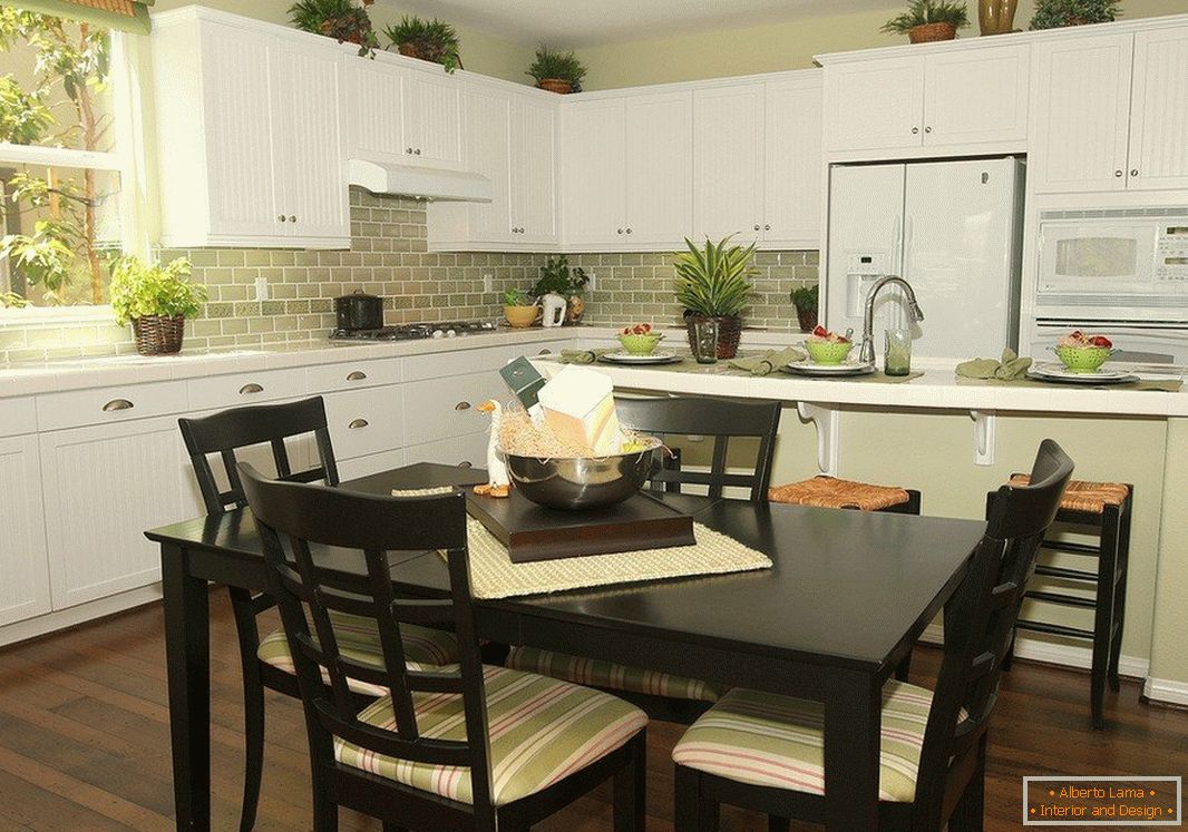 Tavolo nero con sedie e mobili bianchi in cucina