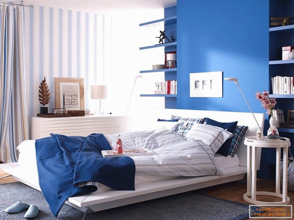 Parete blu nella camera da letto combinata con carta da parati a righe