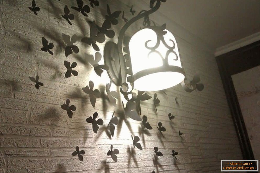Farfalle sul muro con una lampada