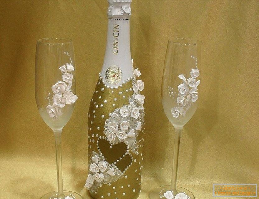 Decorazioni di una bottiglia e bicchieri da vino con rose e perline