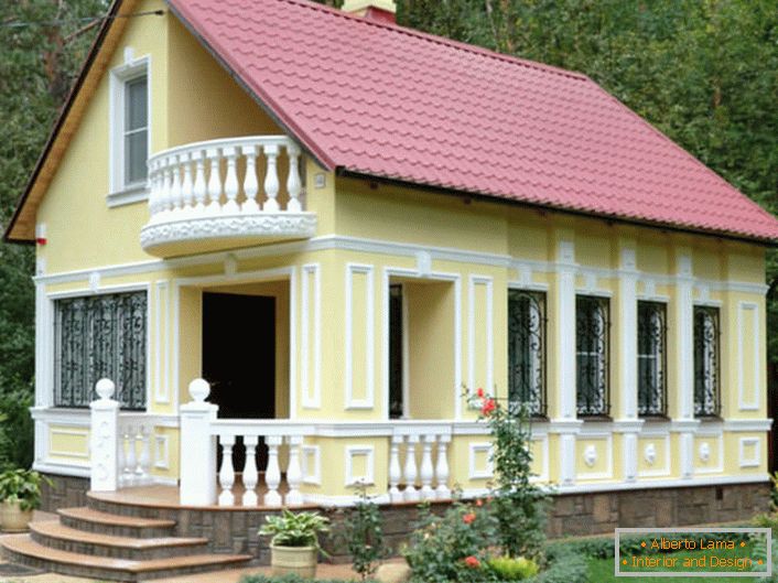 Una piccola casa nella foresta è decorata nello stesso stile. Lo stucco della facciata si attacca allo stile di completezza.