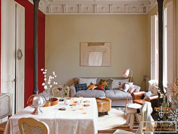 Elegante soggiorno in stile eclettico decorato con cuscini carini. Per la decorazione della stanza del nuovo anno, il proprietario della casa ha scelto un abete rosso interessante con ornamenti eleganti.