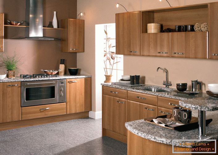Set marrone chiaro di legno naturale per una zona cucina di 12 metri quadrati. La tecnica integrata consente di risparmiare spazio.