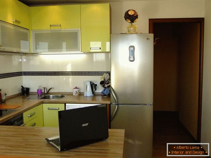 Elegante zona cucina di 12 metri quadrati di tenero color oliva. Lo spazio della cucina è organizzato in modo pratico e funzionale.
