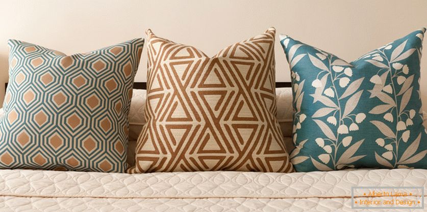 Cuscini decorativi sul letto in tonalità pastello-turchese