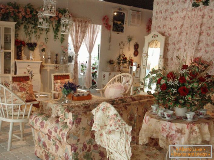 Fiori nel vaso, sul muro e persino sulla tappezzeria del divano. Sala in stile provenzale in una piccola casa di campagna nel sud della Francia.