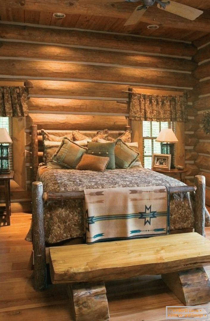 Un classico esempio di camera da letto in stile rustico. Letto interessante di una casa di tronchi grezza e non trattata. 
