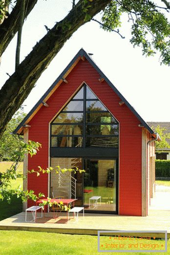 Interno di una piccola casa di legno con grandi finestre